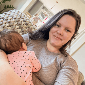 Denise holding a sleeping baby on her chest